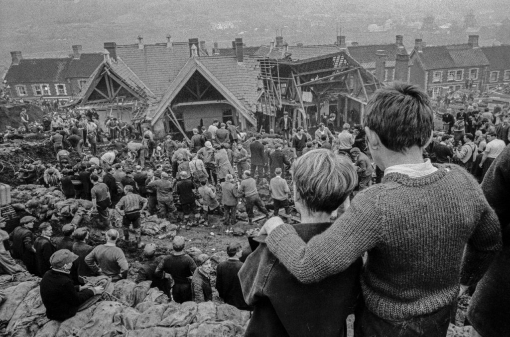 GB. Wales. Aberfan Coal Slip Disaster.  Two surviving children stand at the top of the hill overlooking the miners digging to find children still buried in the slag. Photo: David Hurn.